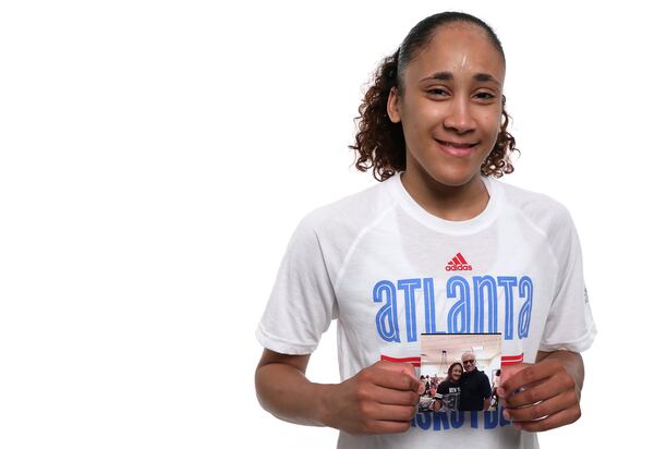 Meighan Simmons, guard for the WNBA’s Atlanta Dream, holds a picture of her with her father, who she says had been the reason for her success in basketball. RYON HORNE / RHORNE@AJC.COM