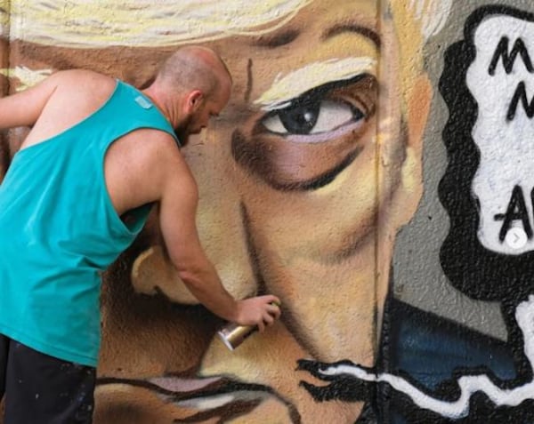 Chris Veal paints a mural featuring former President Donald Trump's mug shot. (Screen shot via Instagram)