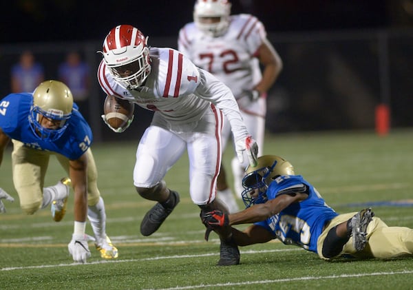 McEachern's Kevin Sherman grabs the leg of Hillgrove's Chigoziem Okonkwo as he runs toward the end zone in November 2016. Okonkwo likely will be selected in the upcoming NFL draft as a tight end. (SPECIAL/Daniel Varnado)