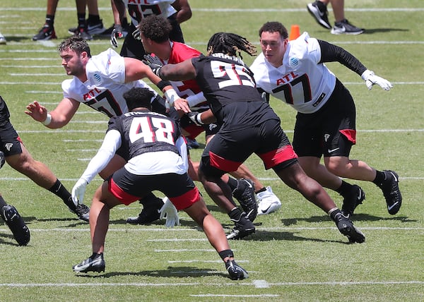 Falcons rookie offensive lineman Drew Dalman (left) and Jalen Mayfield (right) run block on a play during rookie minicamp Friday, May 14, 2021, in Flowery Branch. (Curtis Compton / Curtis.Compton@ajc.com)