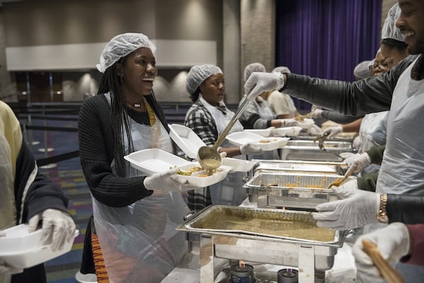 Karson Brown, left, laughs as she prepares a meal during the annual Hosea Helps Thanksgiving dinner at the Georgia World Congress Center in 2017. ALYSSA POINTER/ALYSSA.POINTER@AJC.COM