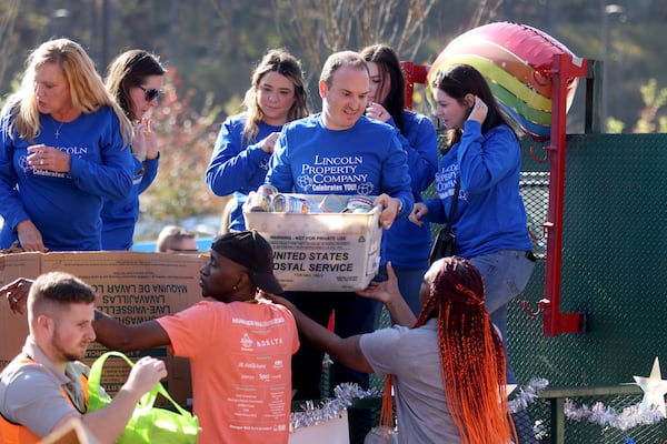 Employees with the Lincoln Property Company unload donations during the Food-A-Thon event at the Atlanta Community Food Bank, Friday, November 4, 2022, in East Point, Ga. (Jason Getz / Jason.Getz@ajc.com)