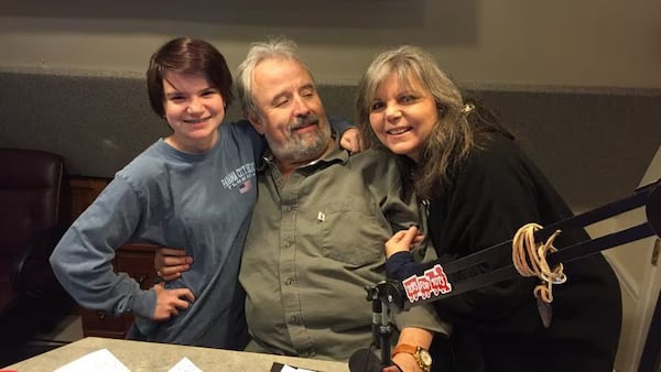 James "Moby" Carney on the final day on air Dec. 30, 2016 before retirement with his daughter Grace and his wife Mary Beth. RODNEY HO/rho@ajc.com