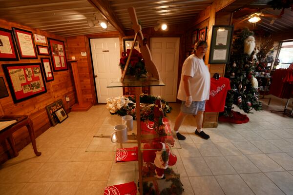 Santa Claus City mayor Donita Bowens walks inside the gift shop that opens to the public Monday through Friday, 9 a.m. to 2 p.m. You can find t-shirts, coffee mugs, and other items with the city's name. In addition, inside the building is a small museum with photographs of the tiny community's history.
 Miguel Martinez / miguel.martinezjimenez@ajc.com