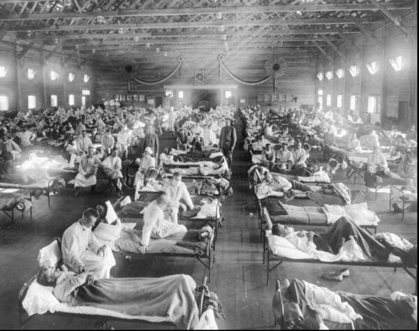 In this 1918 photograph, flu victims crowd into an emergency hospital at Camp Funston, a subdivision of Fort Riley in Kansas. The flu, which is believed to have originated in Kansas, killed at least 20 million people worldwide. (AP Photo/National Museum of Health, ho)