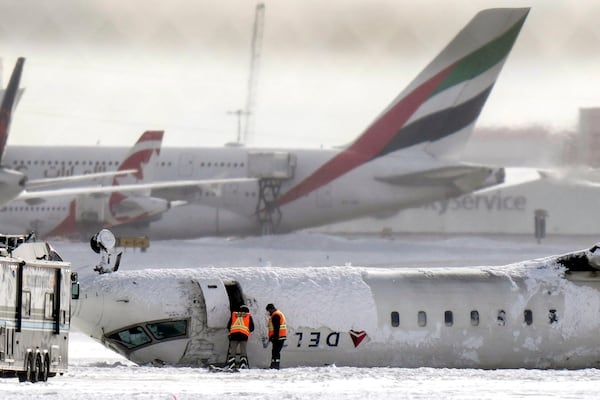 A Delta Air Lines plane lies upside down at Toronto Pearson Airport on Tuesday.