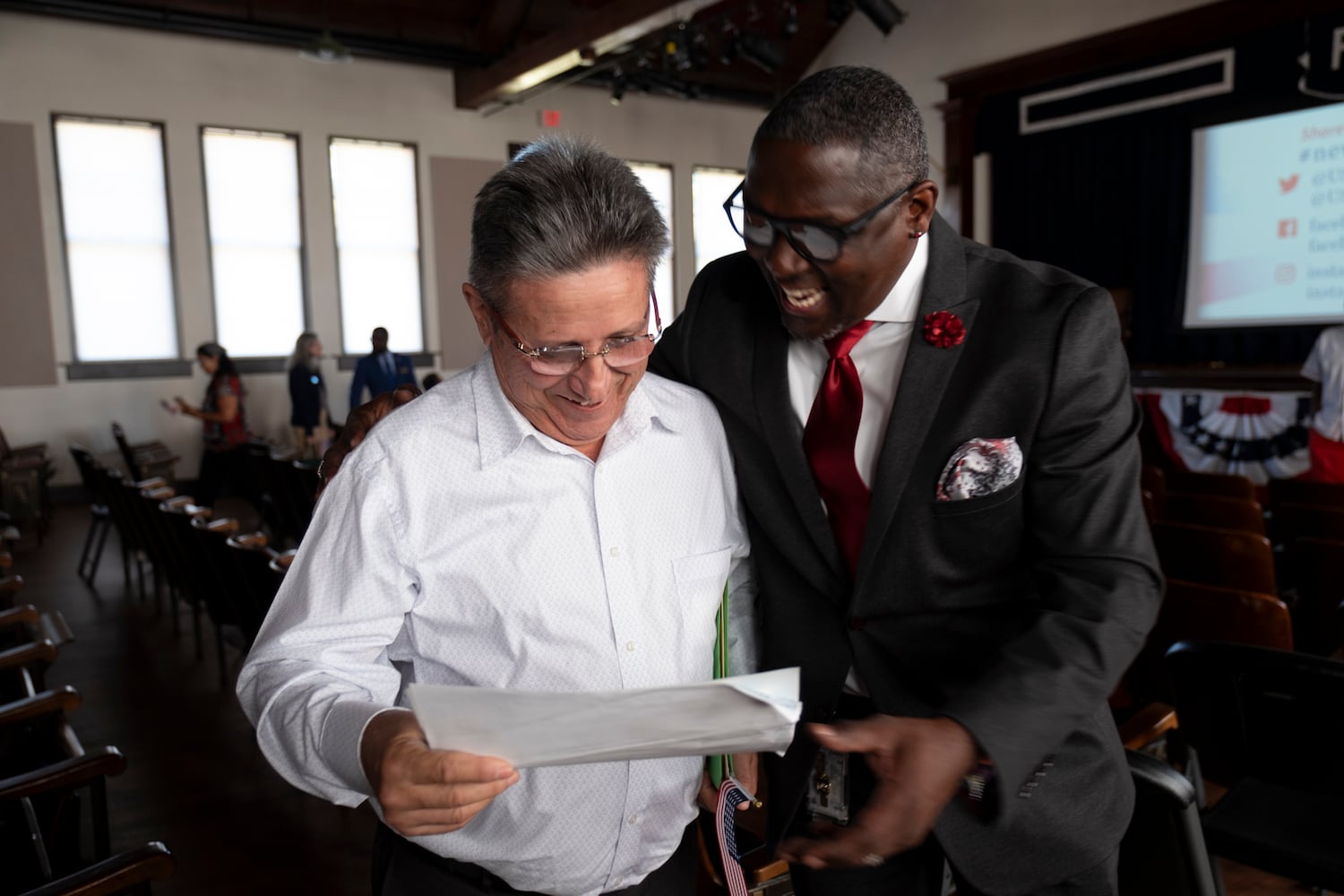 Celso Serrano, from Cuba, receives his Certificate of Naturalization from Dr. Rhomello Saddiq, supervisory immigration services officer for the U.S. Citizenship and Immigration Services department, following a Naturalization ceremony at Jimmy Carter National Historic Park in Plains on Tuesday, Oct. 1, 2024. The ceremony was held in honor of President Carter’s 100th birthday.  Ben Gray for the Atlanta Journal-Constitution