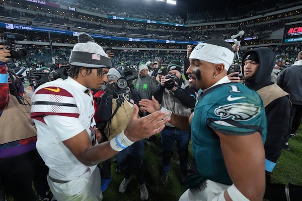 Philadelphia Eagles quarterback Jalen Hurts (1) and Washington Commanders quarterback Jayden Daniels shake hands following an NFL football game Thursday, Nov. 14, 2024, in Philadelphia. The Eagles won 26-18. (AP Photo/Chris Szagola)