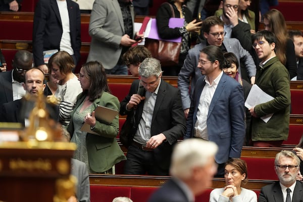 Leftist parliament members leave as French Prime Minister Michel Barnier delivers his speech at the National Assembly while France's minority government may be on its last legs as opposition lawmakers moved this week toward a no-confidence vote, Monday, Dec. 2, 2024 in Paris. (AP Photo/Michel Euler)