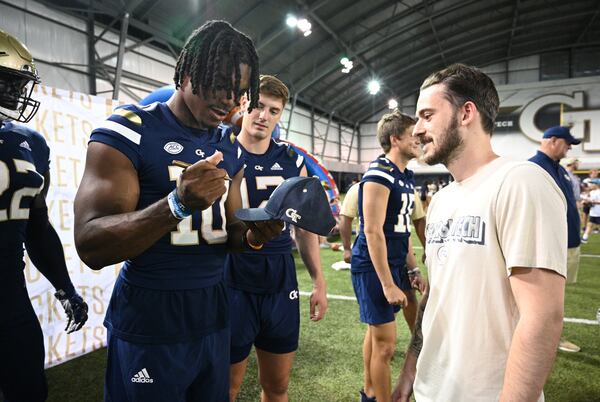 Georgia Tech's quarterback Jeff Sims (10) signs an autograph for Conner Rudolph. (Hyosub Shin / Hyosub.Shin@ajc.com)