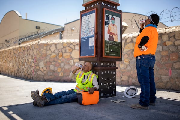 Workers Miguel Ángel Moreno, left, and Javier Quezada take a break from work and try to cool off in the shade from the extreme heat in El Paso, Texas, on Tuesday. On Monday, when soaring temperatures drove electricity demand in Texas to a June record, state regulators asked citizens to use less power or face a repeat of the deadly failures in February that left 69% of Texans without electricity and half without water.