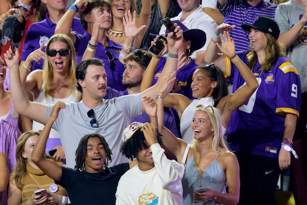 FILE - Fans cheer for LSU during the fourth quarter including Pittsburgh Pirates pitcher Paul Skenes, center left, who helped LSU win the 2023 Men's College World Series, and his girlfriend Olivia "Livvy" Dunne, bottom right, who helped LSU win the 2024 NCAA gymnastics national championship along with Haleigh Bryant, above Dunne, during an NCAA college football game against Mississippi in Baton Rouge, La., Saturday, Oct. 12, 2024. (AP Photo/Matthew Hinton, File)