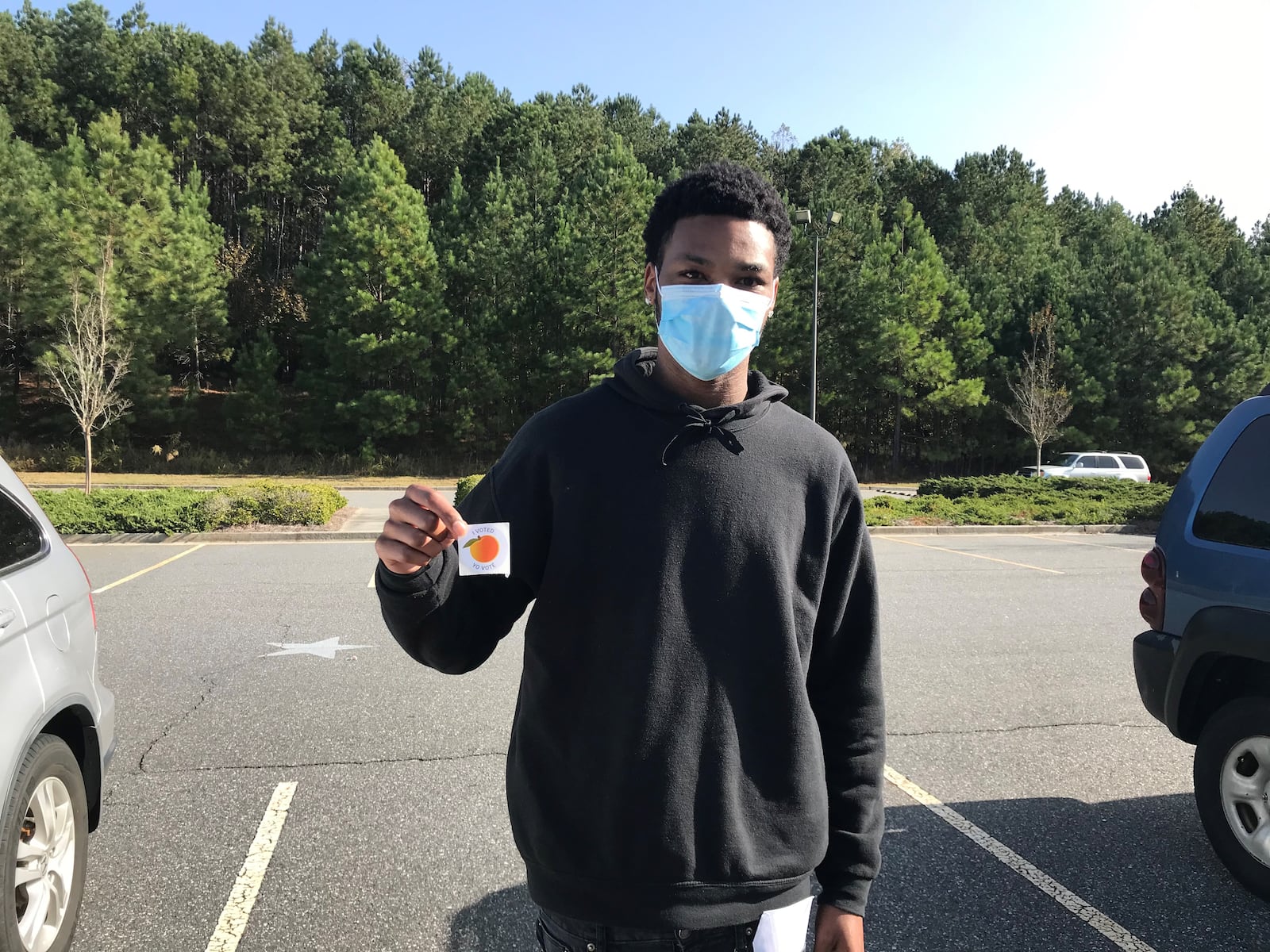 Anthony Sledge, 20, voted Tuesday in Gwinnett County and then flashed his voting sticker outside Anderson-Livsey Elementary School in Snellville. VANESSA McCRAY/AJC