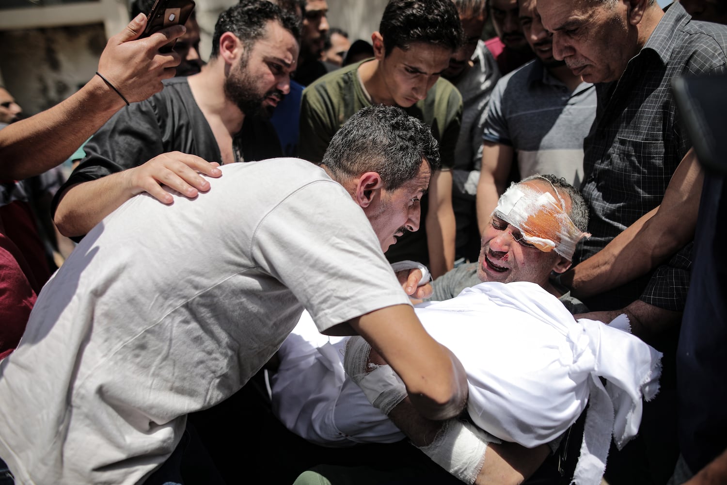 A victim of an Israeli airstrike mourns the loss of family members in Gaza City, Gaza Strip, May 16, 2021. (Hosam Salem/The New York Times)