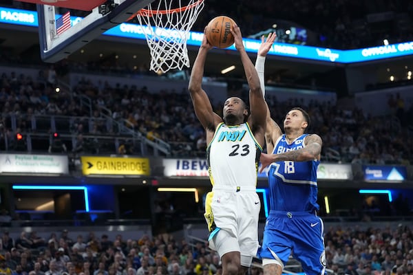 Indiana Pacers forward Aaron Nesmith (23) shoots in front of Milwaukee Bucks forward Kyle Kuzma (18) during the second half of an NBA basketball game in Indianapolis, Tuesday, March 11, 2025. (AP Photo/AJ Mast)