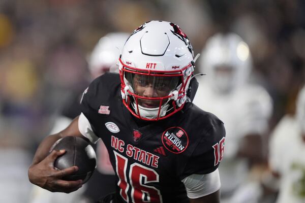 North Carolina State quarterback CJ Bailey (16) runs the ball in for a touchdown during the first half of an NCAA college football game against Georgia Tech, Thursday, Nov. 21, 2024, in Atlanta. (AP Photo/Brynn Anderson)