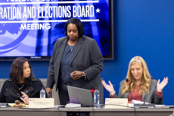 Fulton County election board member Julie Adams, right, reacts to information in an election summary packet during a meeting Tuesday in Union City. The board certified election results shortly after missing its 5 p.m. deadline. (Arvin Temkar / AJC)