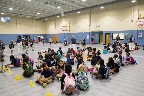 Students wait to be guided to their teachers during the first day of school at Brumby Elementary School in Marietta, Wednesday, Aug. 1, 2018.  (ALYSSA POINTER/ALYSSA.POINTER@AJC.COM)