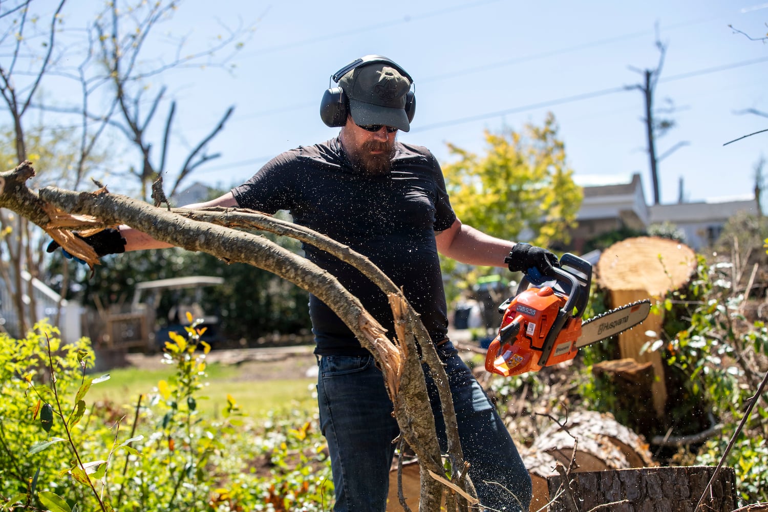 Jason Rose cleans up downed trees in the backyard of his mother’s property in Newnan. (Alyssa Pointer / Alyssa.Pointer@ajc.com)