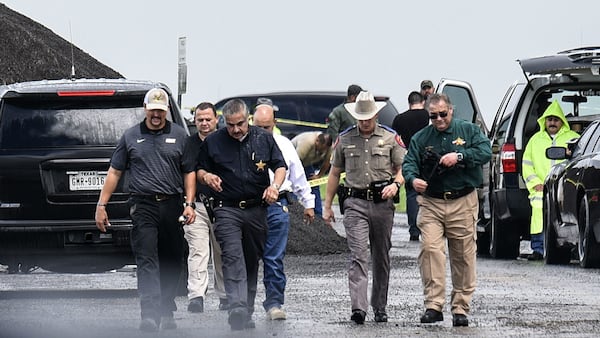 Law enforcement officers are pictured Saturday, Sept. 15, 2018, at the scene where the body of a woman was found near Interstate 35 north of Laredo, Texas. Juan David Ortiz, a U.S. Border Patrol agent, is suspected of the serial killings of four women and the assault of a fifth woman who escaped and notified authorities.