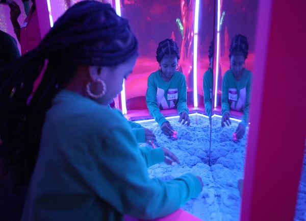 Seven-year-old Nuri Barnes, of McDonough, plays in the magnetic sand area in the slime-filed experience of Sloomoo in Buckhead, Wednesday, November 16, 2022, in Atlanta. Jason Getz / Jason.Getz@ajc.com)