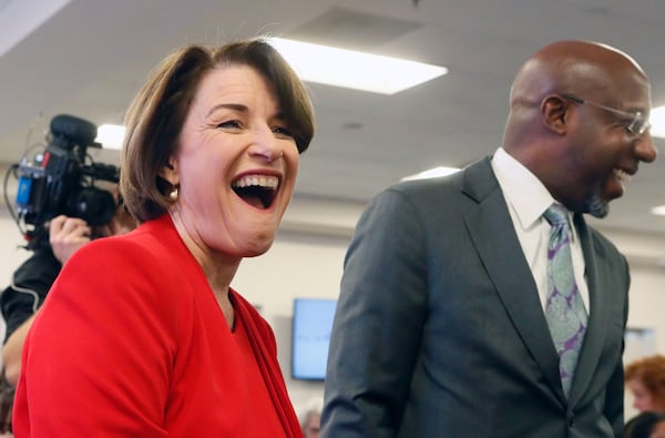 November 21, 2019 - Atlanta - Amy Klobuchar shares a laugh with Ebenezer Baptist Church pastor Rev. Raphael G. Warnock.  Democratic presidential candidates including Cory Booker, Amy Klobuchar, Andrew Yang and Pete Buttigieg, along with Stacey Abrahms,  were calling and texting voters Thursday whose registrations could be canceled in Georgia at a Fair Fight phone bank at Ebenezer Baptist Church in Atlanta. The phone bank was in response to Georgia election officials' plan to cancel more than 313,000 voter registrations next month.   Bob Andres / robert.andres@ajc.com