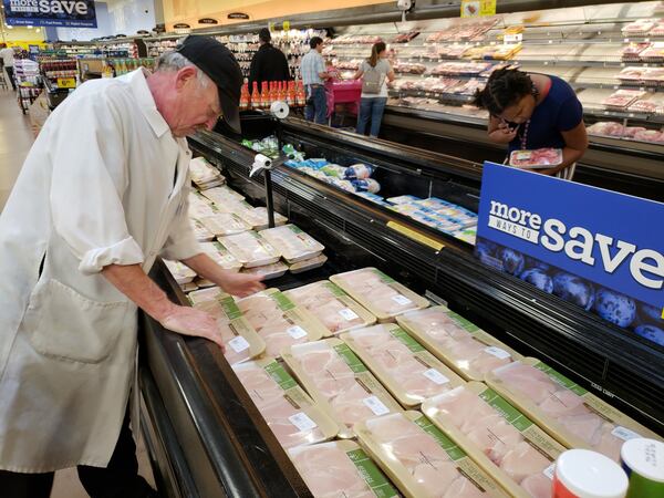 In a file photo of a grocery in Gainesville, a city that dubs itself the Poultry Capital of the World, a butcher stocks cases with plenty of chicken. MATT KEMPNER / AJC