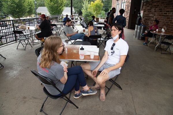 Lara Hulbert (left) and Sean McTagne eat brunch on the patio of Krog Street Market on Saturday, September 26, 2020. STEVE SCHAEFER / SPECIAL TO THE AJC