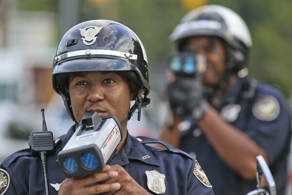 Atlanta police Officers T. Chambliss (foreground) and D. Brown in August 2012 as they waited with their laser guns for speeders on Hope Street and Metropolitan Avenue. JOHN SPINK / JSPINK@AJC.COM