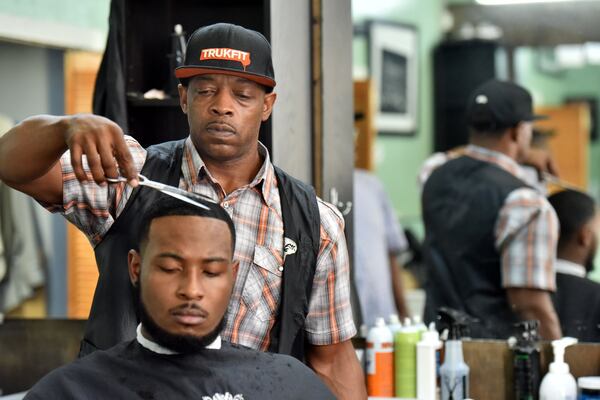 Raefus Cox cuts his customer Chris Anthony’s hair at Vintage Hair Gallery in downtown Atlanta on Friday, August 12, 2016. The most decorated Olympian of all time, Michael Phelps, visits an Atlanta barber shop and then shares his new haircut with the world via a selfie. That’s when Raefus Cox, the barber who cut his Phelps’ hair, first felt the Phelps’ effect. HYOSUB SHIN / HSHIN@AJC.COM