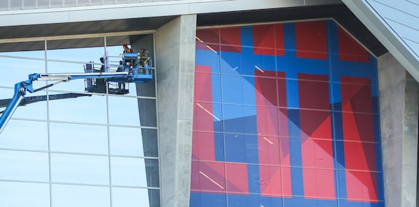 Workers adhere giant Super Bowl graphics on Mercedes Benz Stadium Structures as structures and Super Bowl related imagery are popping up everywhere across Atlanta. 