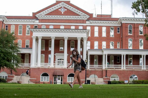 A Georgia College and State University student wears a face mask while traveling though the campus in Milledgeville, Friday, Aug. 21, 2020.  (Alyssa Pointer / Alyssa.Pointer@ajc.com)