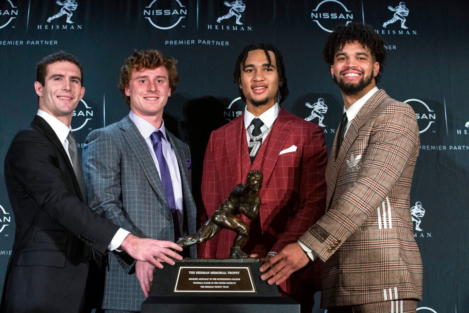 Heisman trophy finalists, from left, Georgia quarterback Stetson Bennett, TCU quarterback Max Duggan, Ohio State quarterback C.J. Stroud and Southern California quarterback Caleb Williams stand for a photo with the Heisman Trophy before attending the award ceremony, Saturday, Dec. 10, 2022, in New York. (AP Photo/Eduardo Munoz Alvarez)