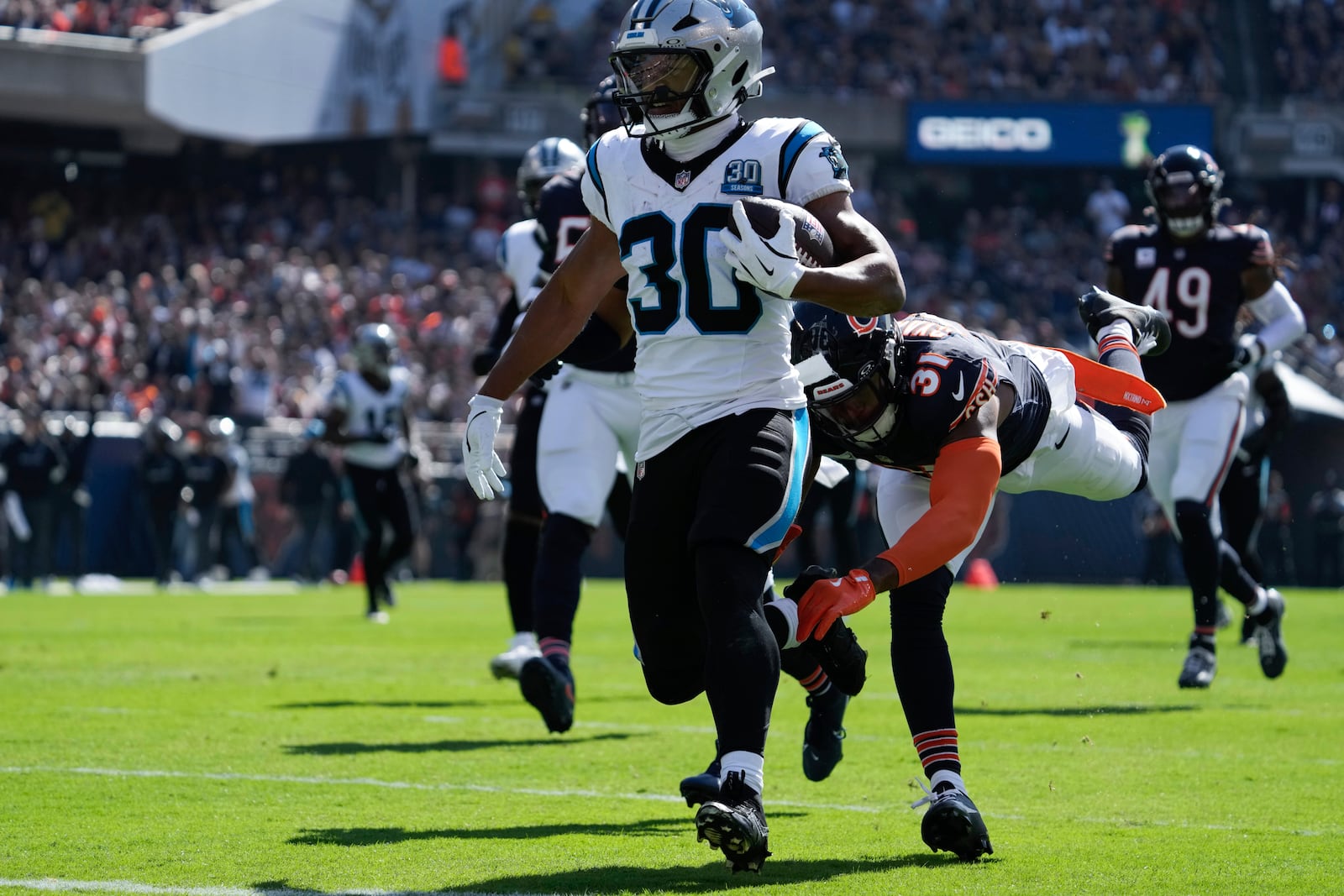 Carolina Panthers running back Chuba Hubbard (30) scores on a 38-yard touchdown run as Chicago Bears safety Kevin Byard III (31) defends during the first half of an NFL football game Sunday, Oct. 6, 2024, in Chicago. (AP Photo/Nam Y. Huh)