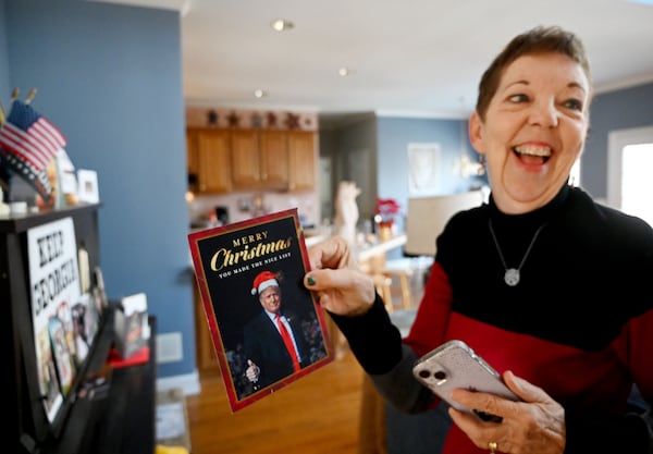 Judy Griffin smiles as she shows a holiday card she received at her home in Woodstock. (Hyosub Shin/AJC)