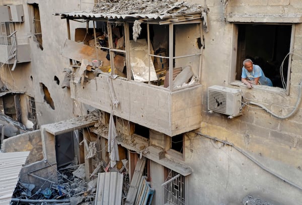 A resident looks through his damaged house at the site of an Israeli airstrike hit central Beirut, Lebanon, Saturday, Nov. 23, 2024. (AP Photo/Hassan Ammar)