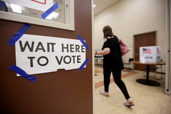 A voter heads to a booth to cast her ballot. The state this past week completed its latest round of canceling voter registrations, this time making nearly 189,000 people ineligible to vote unless they re-register. (JASON GETZ/SPECIAL TO THE AJC)