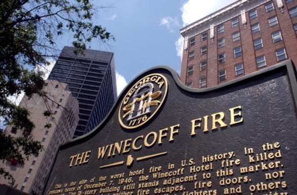 A historic marker stands in front of the old Winecoff Hotel (now the Ellis Hotel) with the Equitable Building soaring behind it on the left. The Winecoff burned on December 7, 1946, killing 119. It remains the country's worst hotel fire.