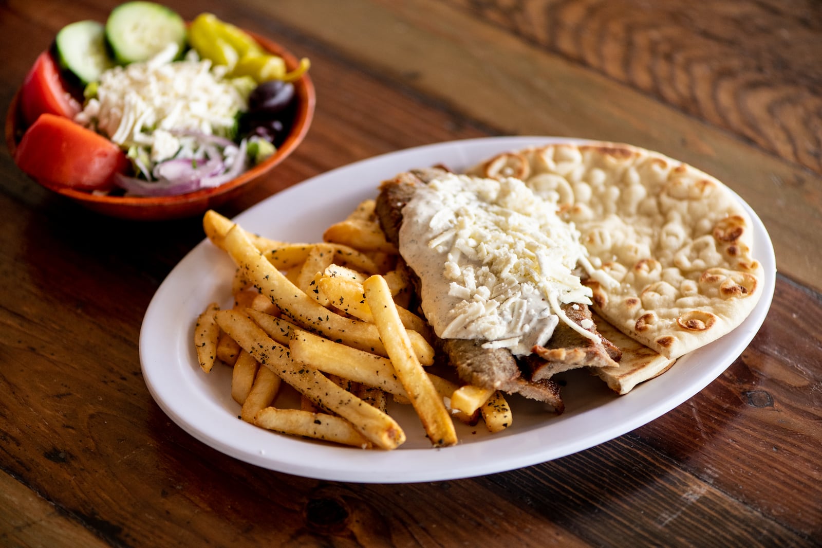 The Greek Pizzeria and Gyros lives up to the other part of its name with dishes such as the Classic Gyro Platter with sliced meat, tzatziki, feta spread, and pita. (Mia Yakel for The Atlanta Journal-Constitution)