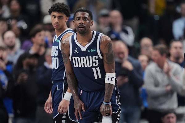 Dallas Mavericks' Kyrie Irving (11) and Max Christie, left, look on after Irving suffered an unknown injury in the first half of an NBA basketball game against the Sacramento Kings in Dallas, Monday, March 3, 2025. (AP Photo/Tony Gutierrez)