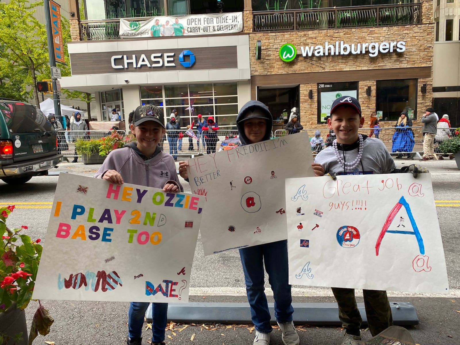 Olivia Rose, 11, Channing Pittman, 10, and Cooper Rose, 11, of Walton County made their own signs to cheer on the Braves. VANESSA McCRAY/AJC