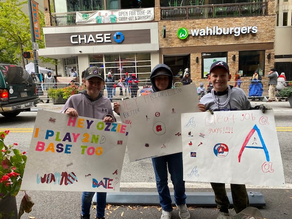 Olivia Rose, 11, Channing Pittman, 10, and Cooper Rose, 11, of Walton County made their own signs to cheer on the Braves. VANESSA McCRAY/AJC