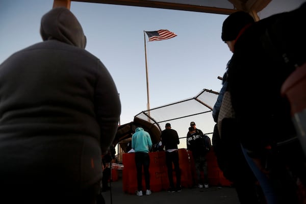 FILE - Migrants line up at the Paso del Norte international bridge to present to U.S. agents documents requesting an appointment to apply for asylum, in Ciudad Juarez, Mexico, Nov. 5, 2024. (AP Photo/Christian Chavez, File)