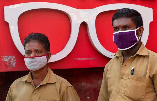 Auto rickshaw drivers wearing masks as a precaution against COVID-19 await customers near an optical shop in Kochi, Kerala state, India, Wednesday, June 24, 2020. India is the fourth hardest-hit country by the coronavirus in the world after the U.S., Russia and Brazil. (AP Photo/R S Iyer)