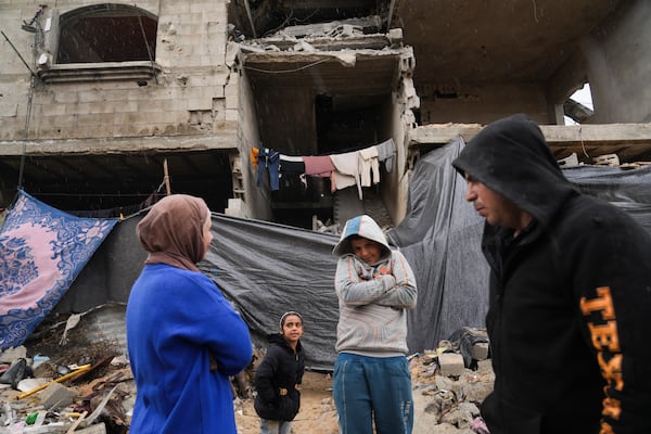 Members of the Tamboura family stand outside their four-story home, which was struck by an Israeli airstrike on Oct. 20, 2023, in Beit Lahiya, northern Gaza Strip, Friday, Feb. 21, 2025. (AP Photo/Abdel Kareem Hana)