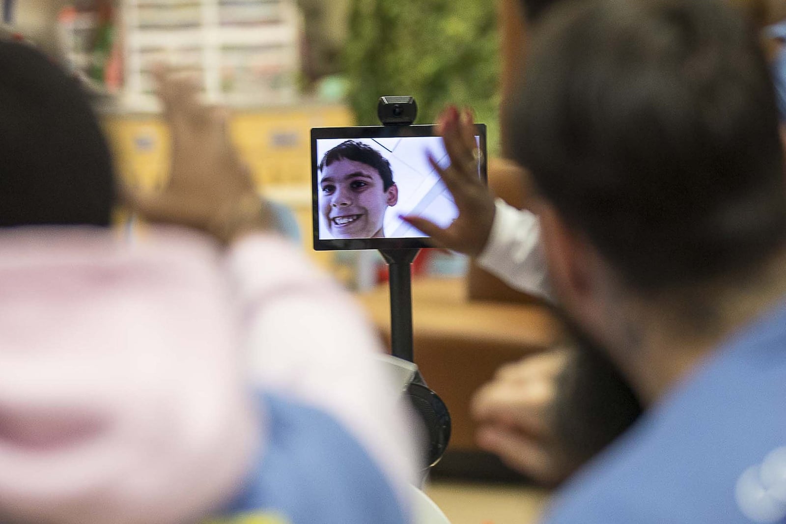 People wave at Jaden Campbell, 11, as he enters an activity room at Children’s Healthcare of Atlanta at Scottish Rite using an OhmniLabs robot on Dec. 19, 2019. (ALYSSA POINTER/ALYSSA.POINTER@AJC.COM)