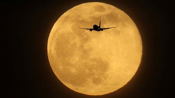 A plane flies in the sky in front of the largest supermoon of 2019 on February 19, 2019 in London, England.