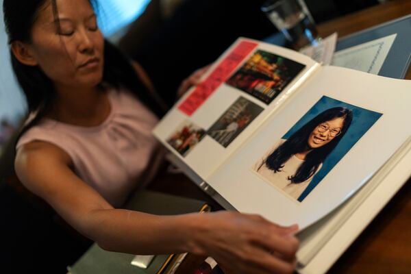 Navy veteran Leah Elmquist shows a childhood photo of her growing up in Nebraska while sifting through mementos in her home, Monday, June 24, 2024, in Las Vegas. She grew up in a white family in a Nebraska town with two stop lights. (AP Photo/David Goldman)