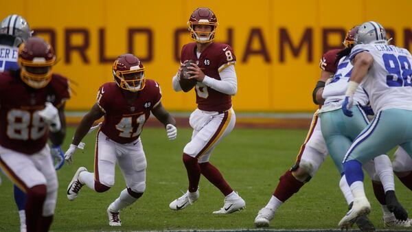 Washington Football Team quarterback Kyle Allen (8) looks down fielding before passing the ball against the Dallas Cowboys Sunday, Oct. 25, 2020, in Landover, Md. (Al Drago/AP)