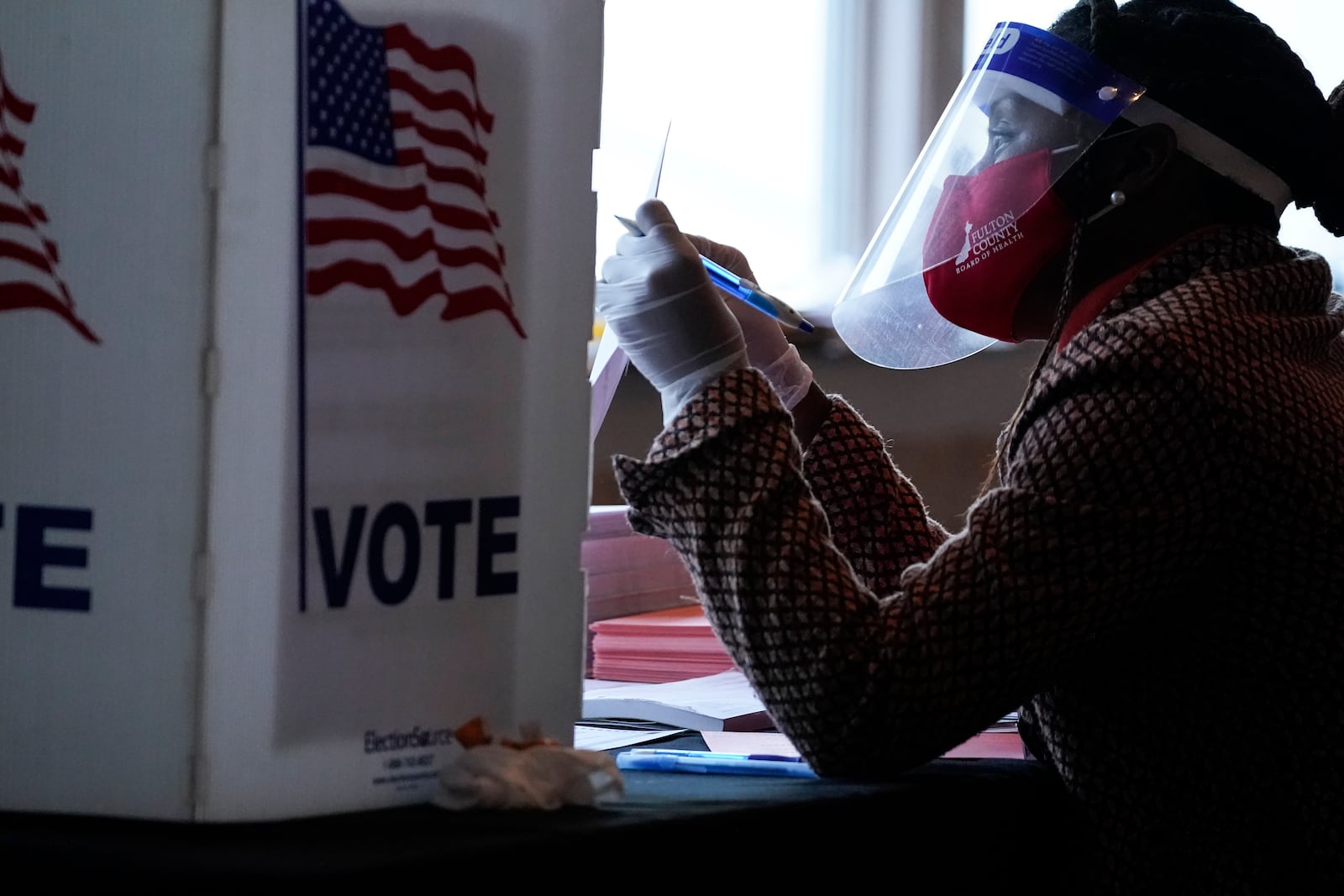 FILE - A poll worker talks to a voter before they vote on a paper ballot on Election Day in Atlanta on Tuesday, Nov. 3, 2020. (AP Photo/Brynn Anderson, File)